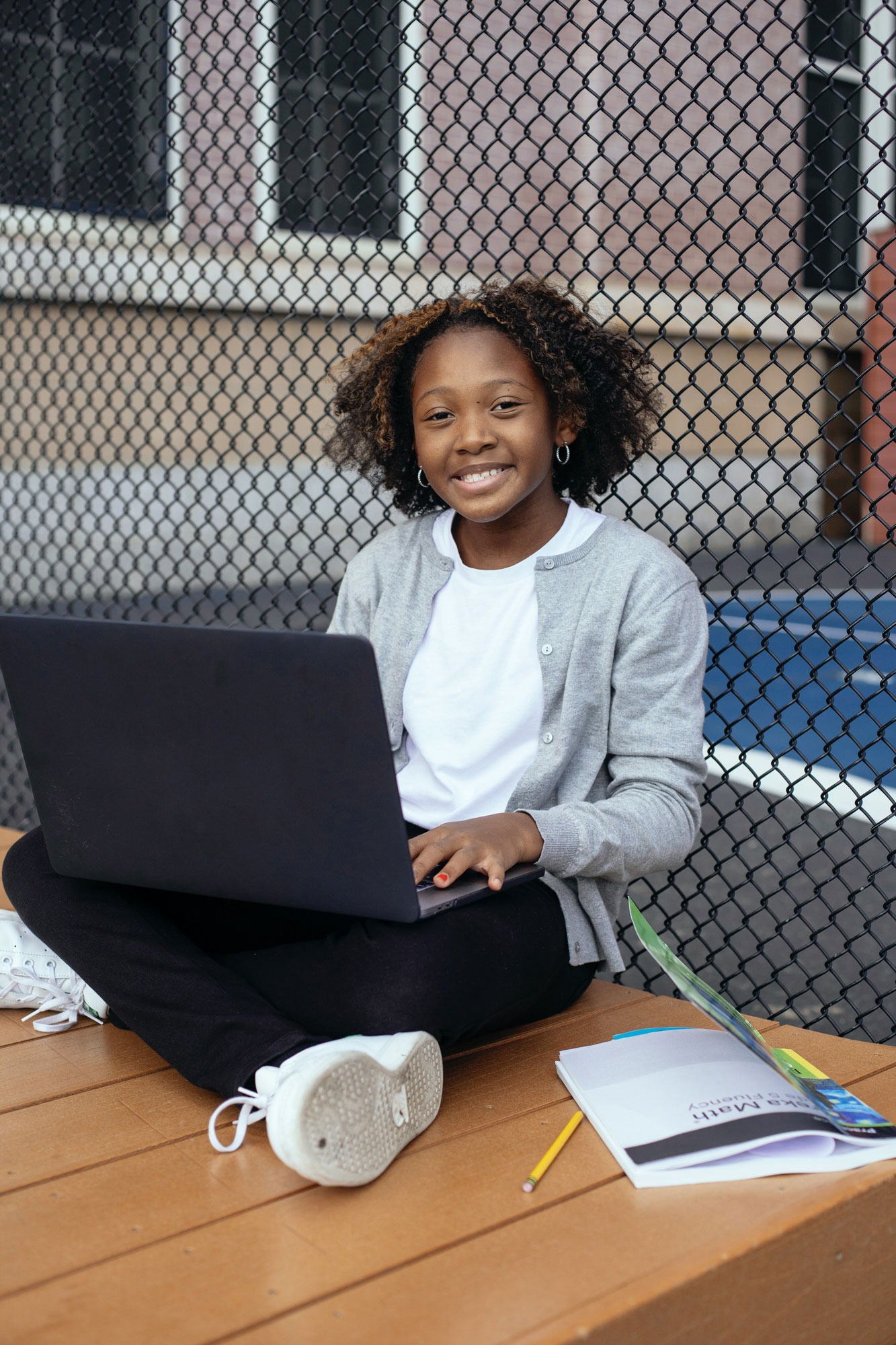 A cute teen smiling and holding a computer